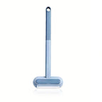 Brosse anti-poils sur pied : manche bleu et base de tête arrondie, design pratique