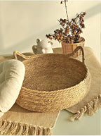 Panier pour chat en rotin rond, intérieur tressé, bord relevé et poignées en corde.