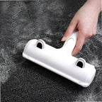 Rouleau anti-poils blanc sur tapis sombre, main en mouvement de nettoyage