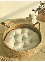 Panier pour chat en rotin rond avec coussin moelleux blanc, poignées en corde.