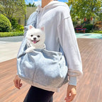 Sac bandoulière bleu clair avec bandoulière et poche avant, avec petit chien à l’intérieur