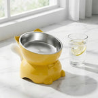 Gamelle pour chat inclinée jaune et blanche avec bols inox, poignées latérales et base stable.