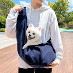 Sac bandoulière bleu foncé avec bandoulière et poche avant, avec petit chien à l’intérieur