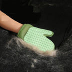 Gant de toilettage double face vert clair, à picots, enlève les poils sur coussin.