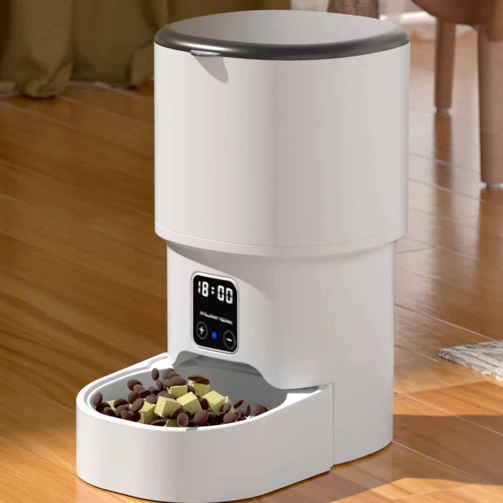 Distributeur automatique blanc avec écran et bac avant contenant des croquettes