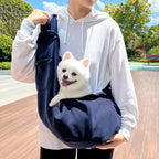 Sac bandoulière bleu foncé avec bandoulière et poche avant, avec petit chien à l’intérieur