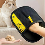 Gant anti-poils noir à maille et bande jaune, posé près d’un chat