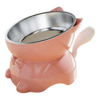 Gamelle pour chat inclinée rose avec bol inox, poignées latérales et support antidérapant.