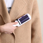 Brosse anti-poils électrostatique blanche à tête violette, utilisée sur manteau beige
