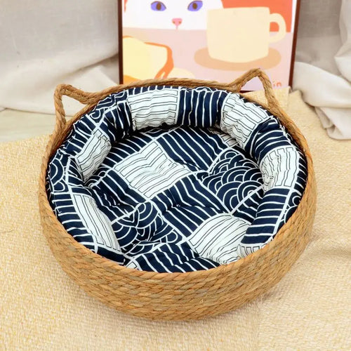Panier pour chat en rotin rond avec coussin moelleux bleu à motifs, poignées en corde.